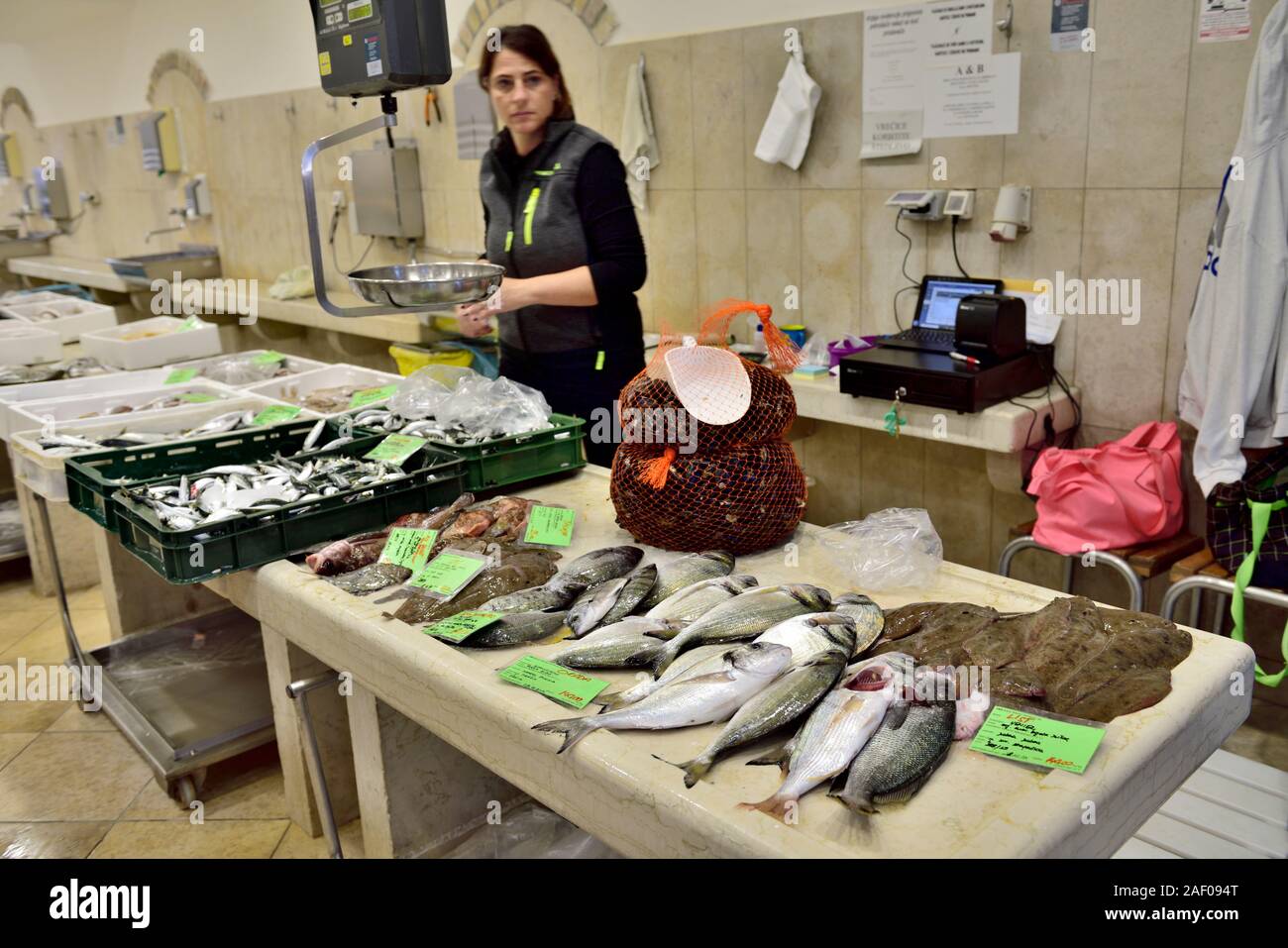 Pesce fresco nelle pescherie mercato con la donna che serve Foto Stock
