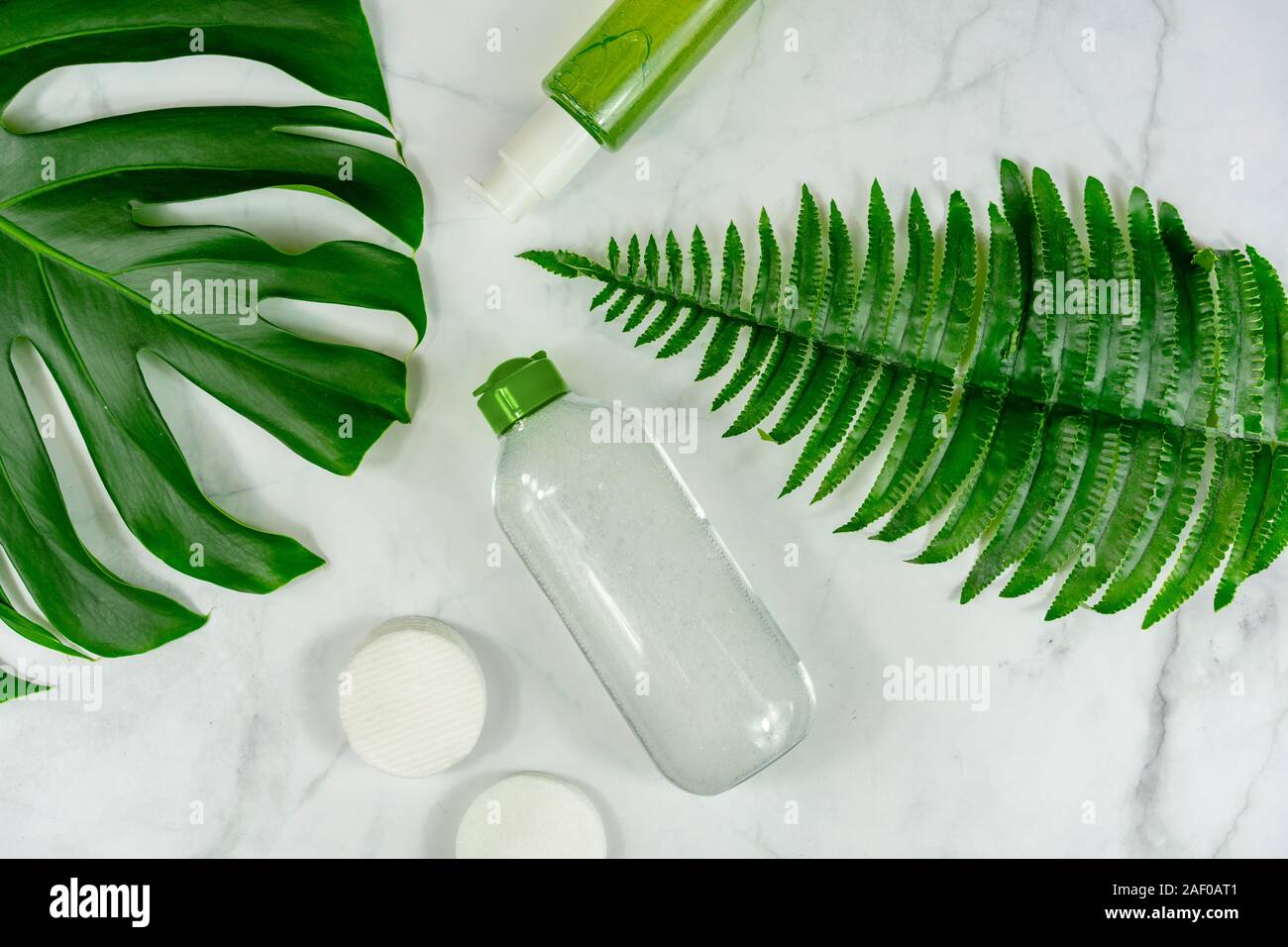 Bio prodotti cosmetici su sfondo marmo con foglie . Foto Stock