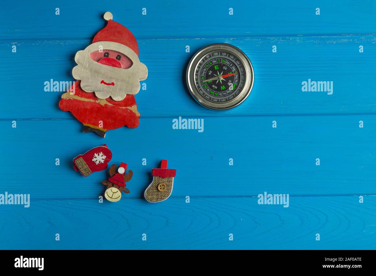 Punti cardinali dove il polo nord è: bussola e figurine di Natale sono su sfondo blu Foto Stock