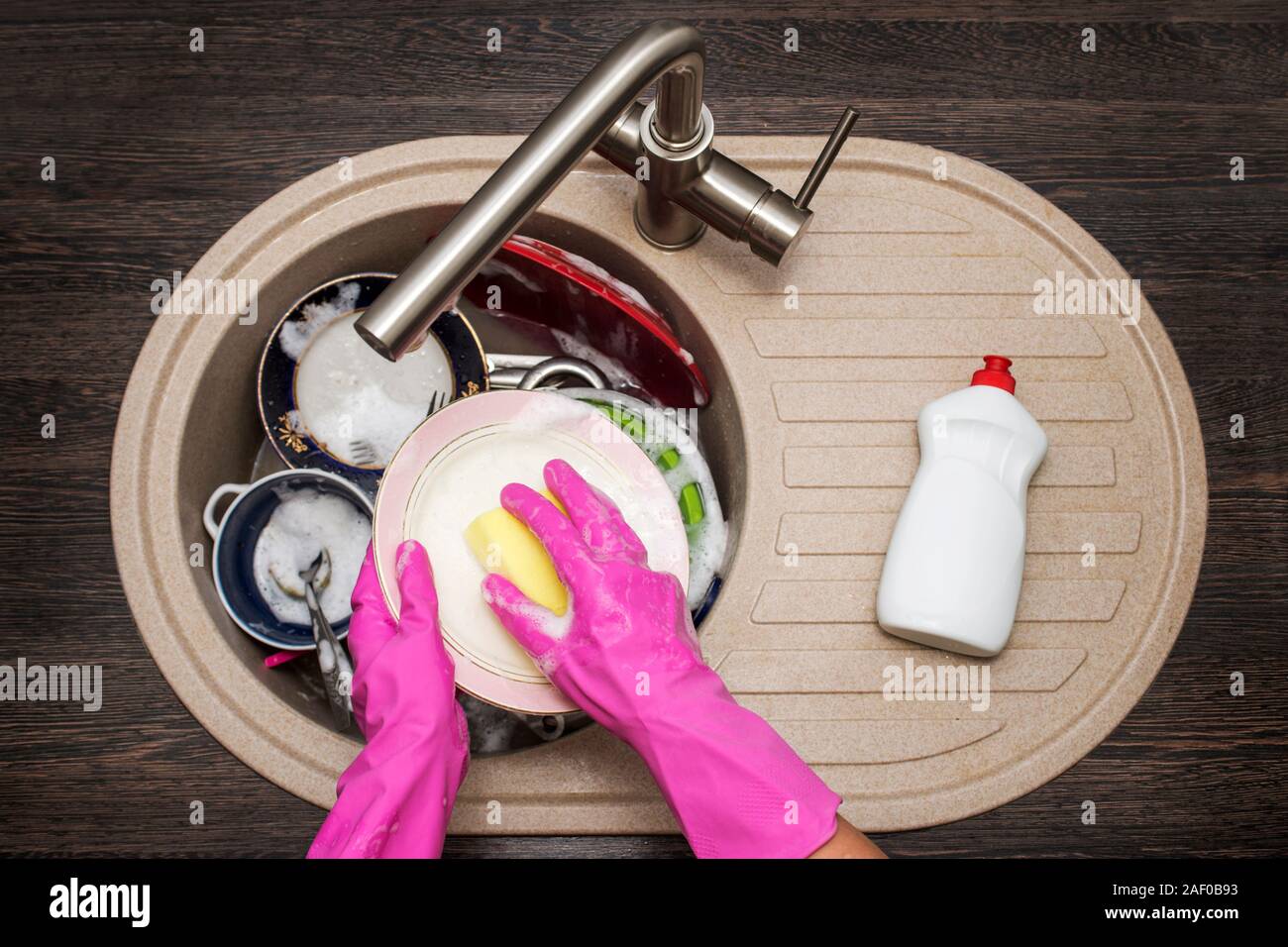 Donna lavaggio piatti nella cucina. Stretta di mano donna. Casalinga piatti puliti. Lavori di casa in cucina. Foto Stock