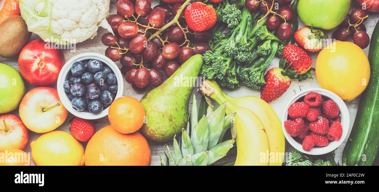 Sani frutti ortaggi riempito di sfondo con Fragole Lamponi arance Prugne Mele Kiwi uva broccoli cauiliflower persimmon mango ananas, tonica, banner Foto Stock