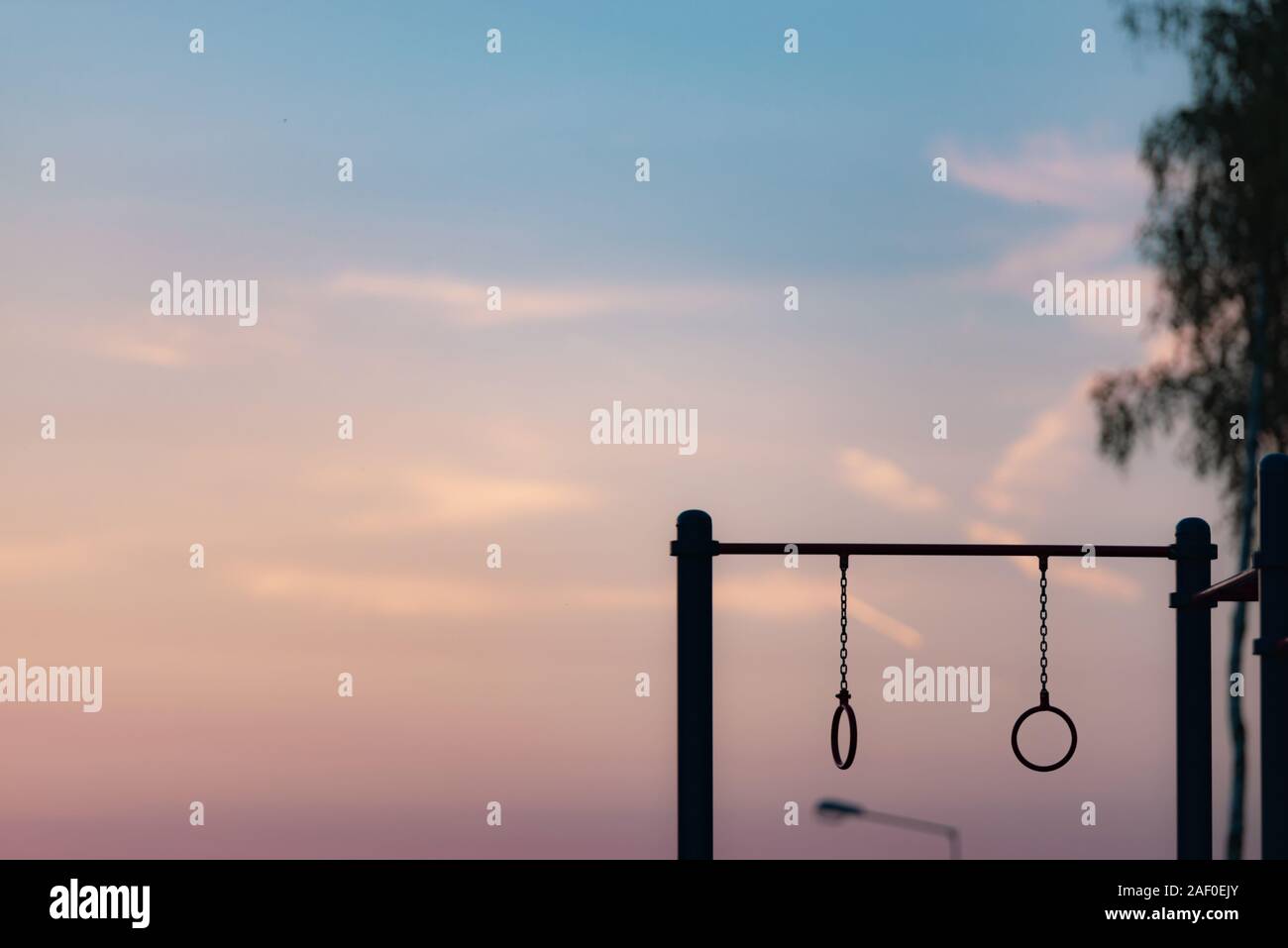 Gli anelli di ginnastica sulla barra. Parco giochi nel cortile al tramonto. Foto Stock