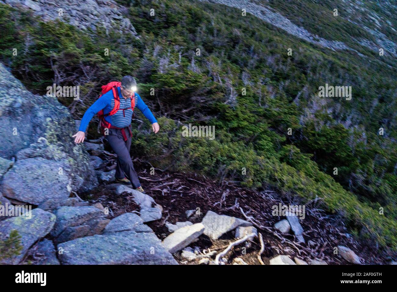 L'uomo escursionismo da proiettore lungo il sentiero roccioso Foto Stock