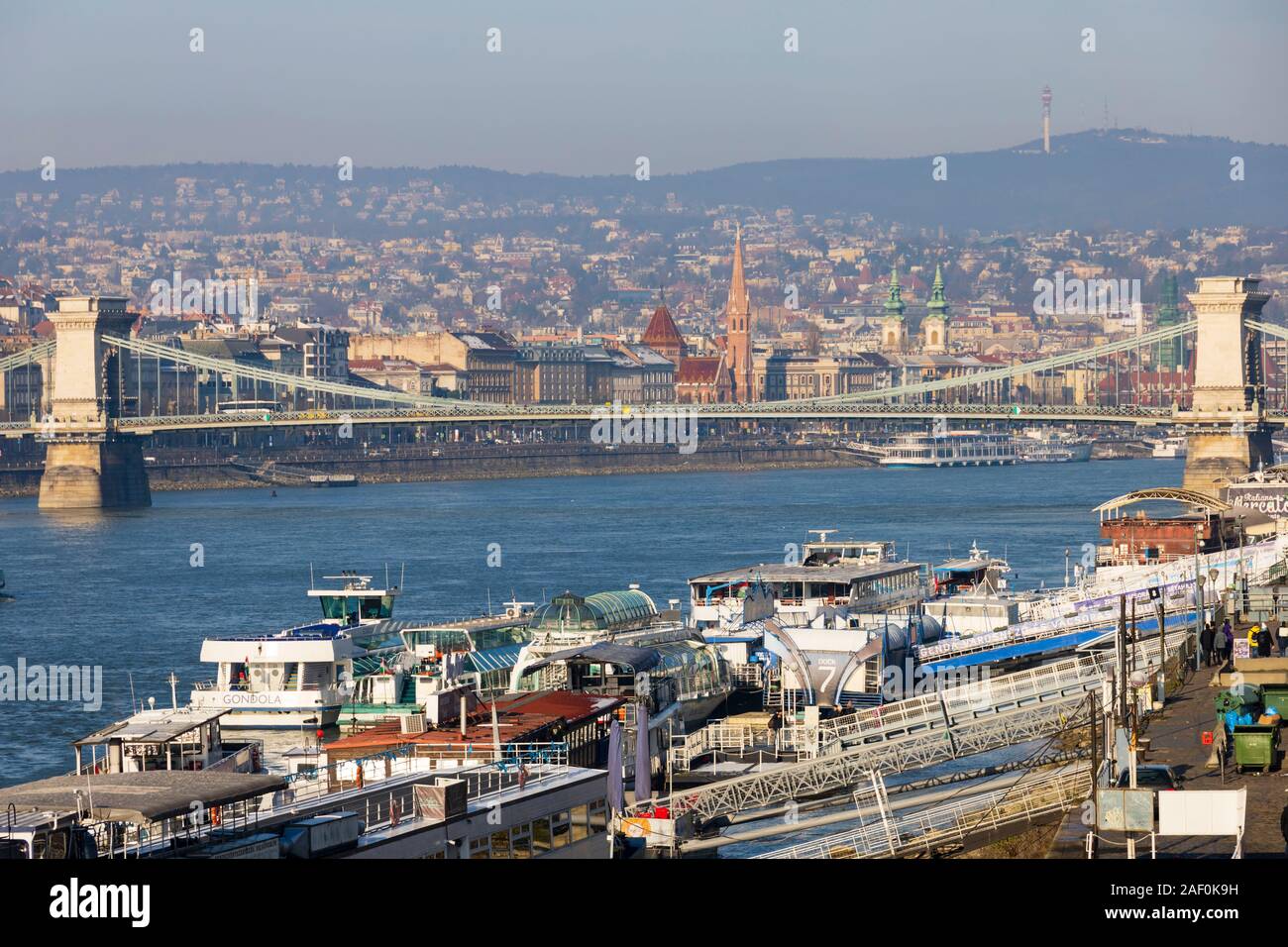 Il Fiume Danubio navi da crociera ormeggiato a Pest, con il ponte della Catena. Inverno a Budapest, Ungheria. Dicembre 2019 Foto Stock