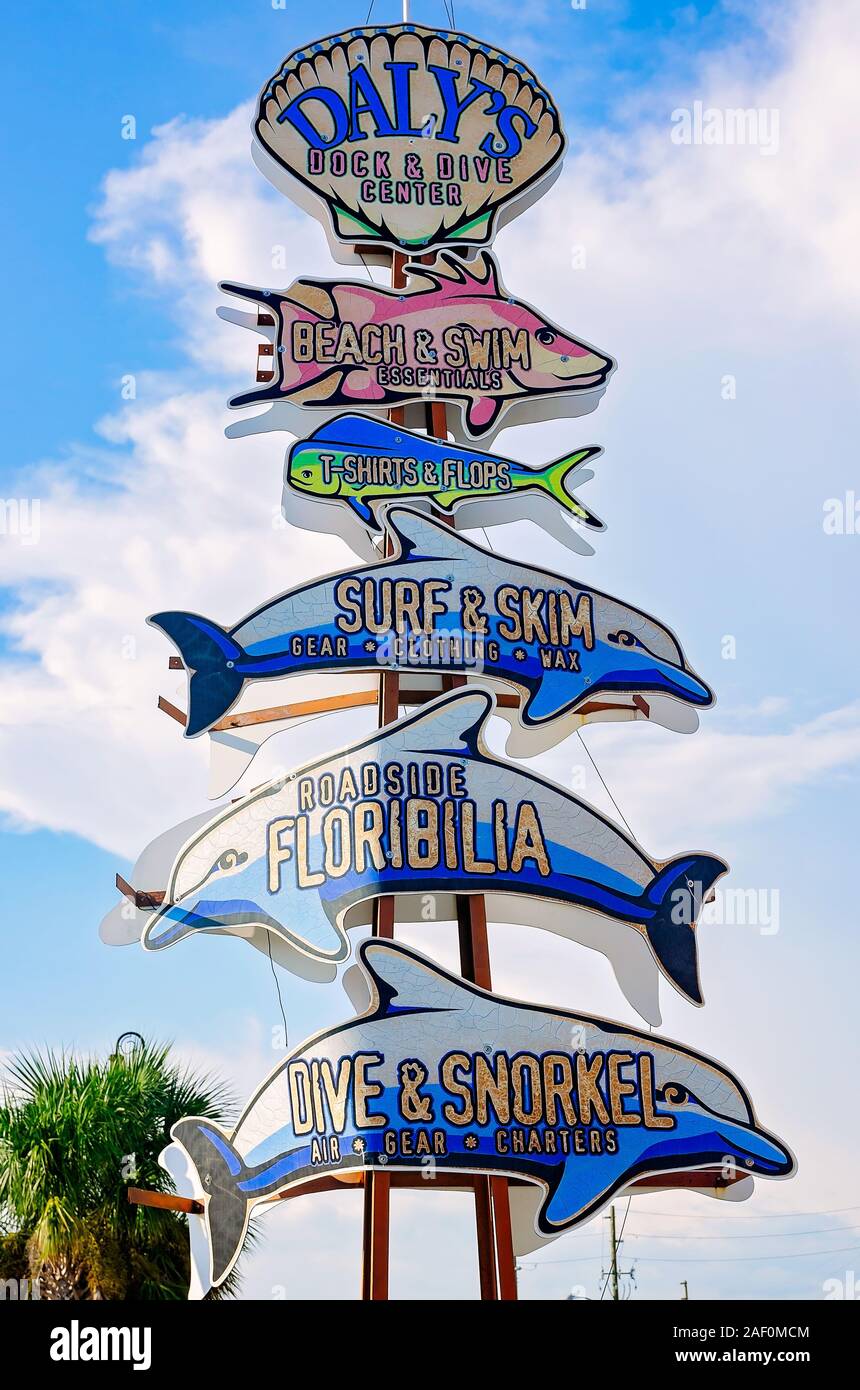 Un segno direzionale utilizza il pesce al posto di frecce per guidare i turisti a cimeli negozi nel centro cittadino di Port St. Joe, Florida. Foto Stock