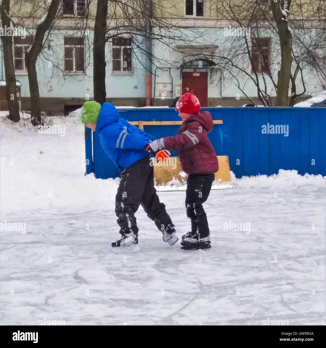 Attività invernali - due ragazzi di diversa età skate. Il bambino più in giovane età si aggrappa ai vecchi. Vacanza in famiglia. Partenza per la natura Foto Stock