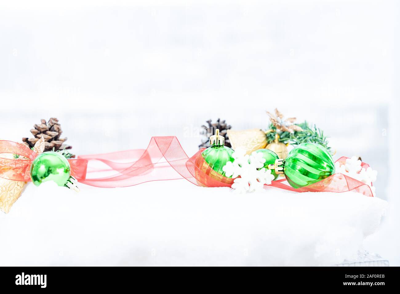 Natale - Baubles decorato, palle di Natale rosa, pino e fiocchi di neve in serpente sfondo Foto Stock