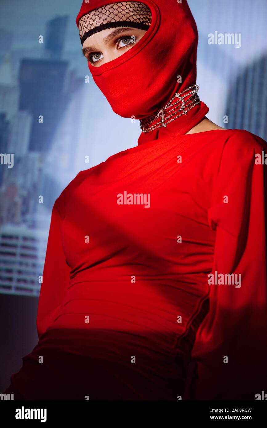 Donna elegante in abito rosso e passamontagna sul background della città  Foto stock - Alamy