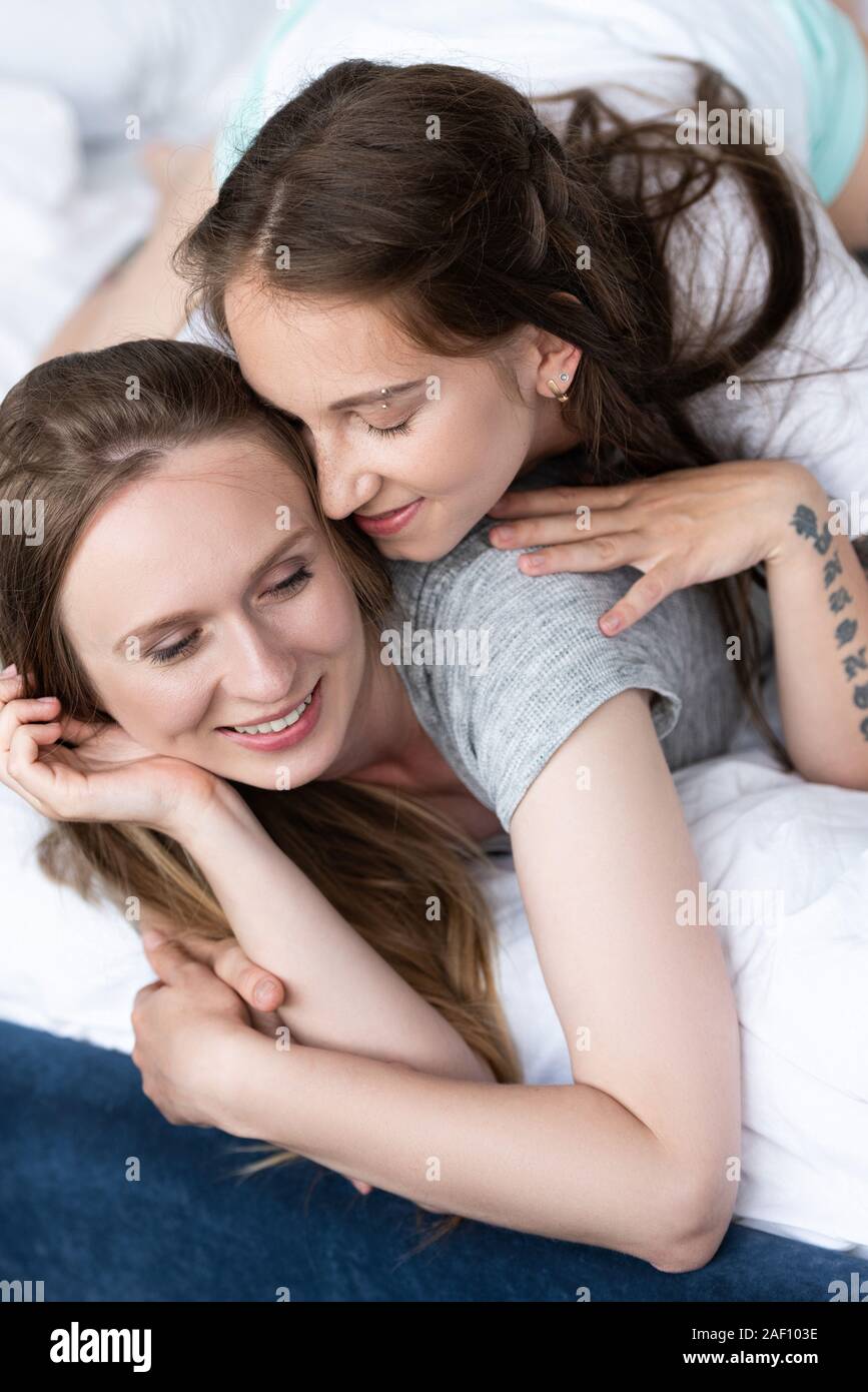 Due lesbiche felici abbracciando sul letto in mattinata Foto stock - Alamy