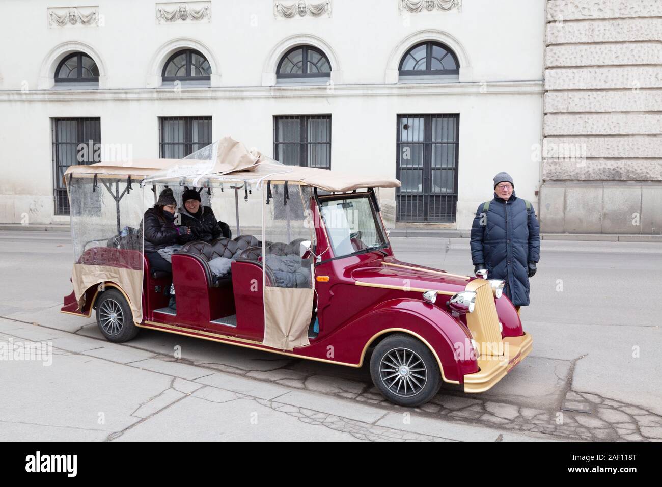 Vienna auto tour - un autista e turisti che vanno su un viaggio riproduzione auto d'epoca per i turisti intorno alla città, Vienna Austria Europa Foto Stock