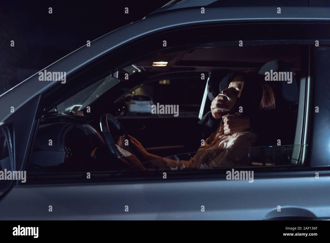 Ladro di attaccare bella donna spaventati in automobile di notte Foto Stock
