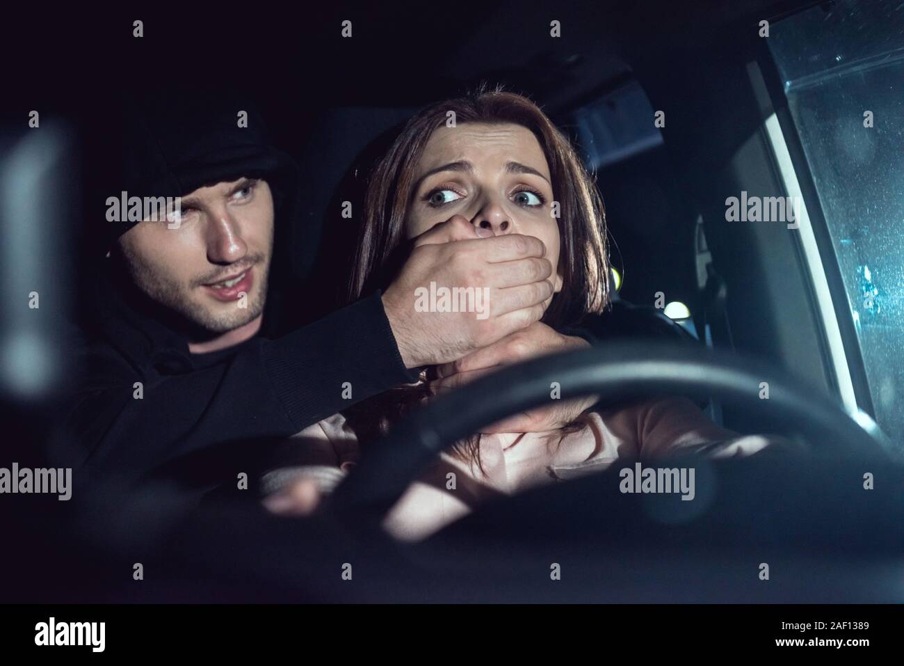 Ladro soffoca la bella donna spaventati in auto Foto Stock