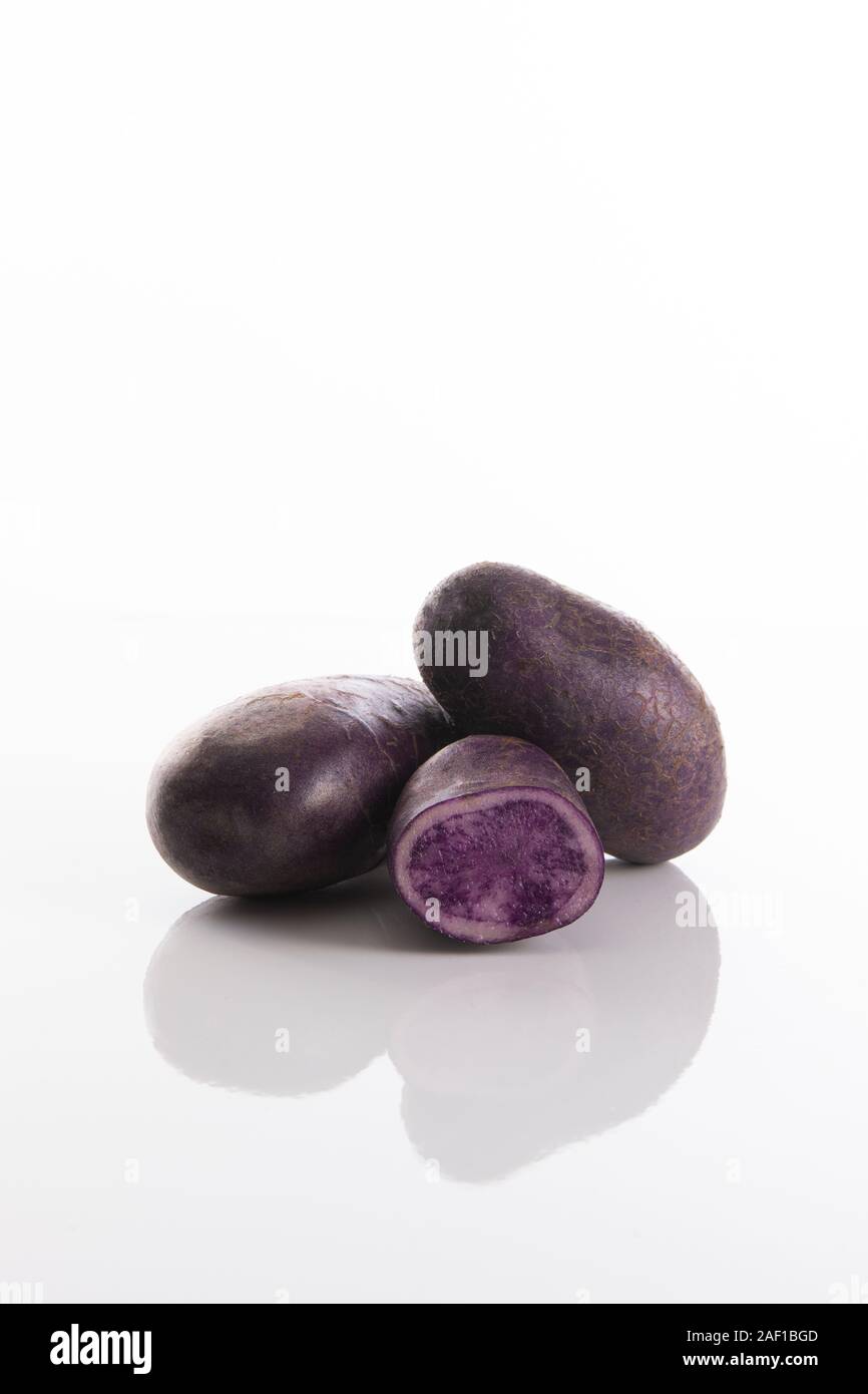 Patate viola con sfondo bianco, Vitelotte noire Foto Stock