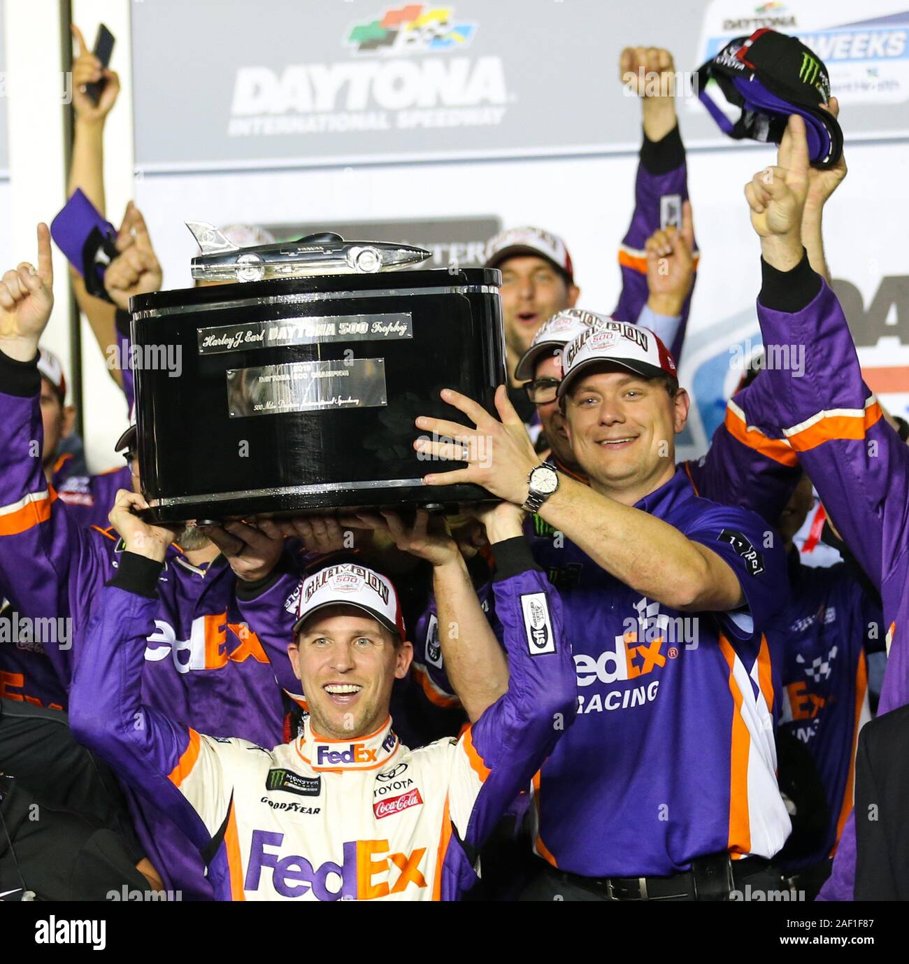 Daytona, Stati Uniti. 12 Dic, 2019. Denny Hamlin, con equipaggio capo Chris Gabehart, solleva la Harley J. Earl trofeo nella corsia di vittoria dopo il 2019 Daytona 500 al Daytona International Speedway Febbraio 17, 2019, Daytona, Florida. Foto di Michael Gentry/UPI Credito: UPI/Alamy Live News Foto Stock