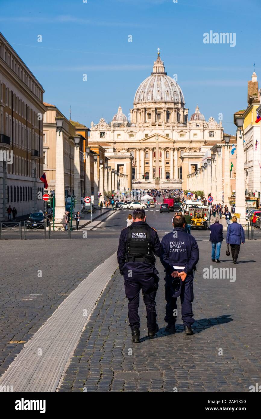 Due uomini di polizia a guardare la larga strada che conduce a Piazza San Pietro e la Basilica Papale di San Pietro, Basilica di San Pietro Foto Stock