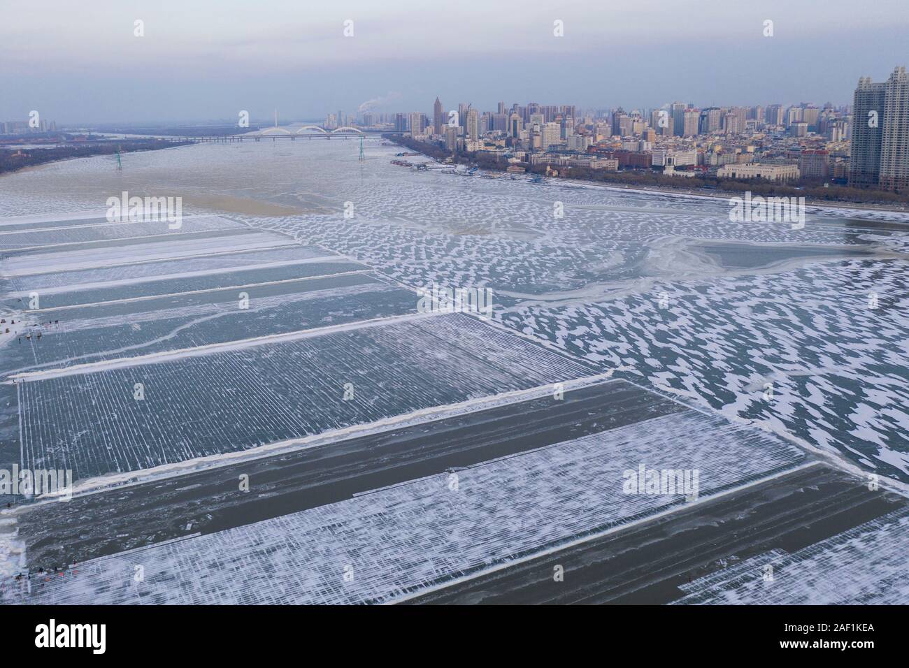 (191212) -- HARBIN, Dic 12, 2019 (Xinhua) -- Foto aeree prese a Dic. 11, 2019 mostra il Songhua Frozen River a Harbin, capitale del nord-est della Cina di Heilongjiang provincia. Cubetti di ghiaccio raccolti dall'congelati fiume Songhua verrà utilizzato nel prossimo snow festival di Harbin. (Foto di Xie Jianfei/Xinhua) Foto Stock