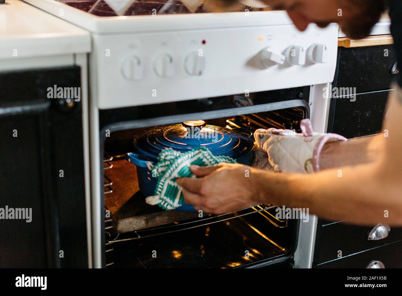 Uomo di mettere pentola all'interno del forno Foto Stock