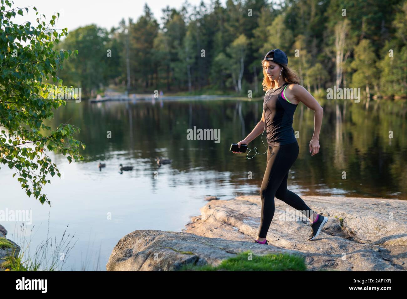 Donna jogging al lago Foto Stock