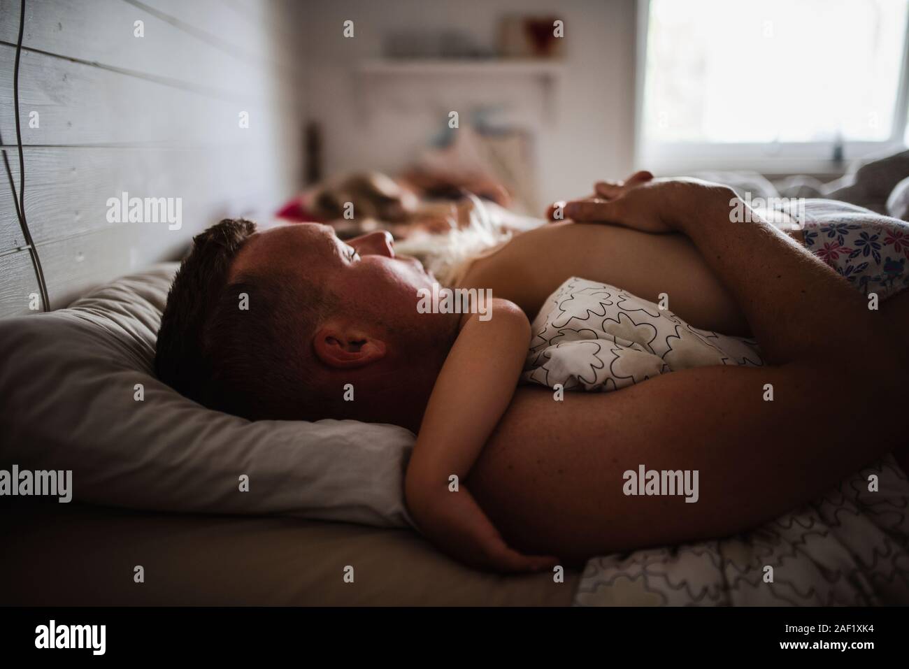 Padre e figlio che dorme nel letto Foto Stock