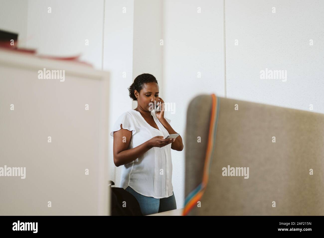 Donna al telefono in ufficio Foto Stock