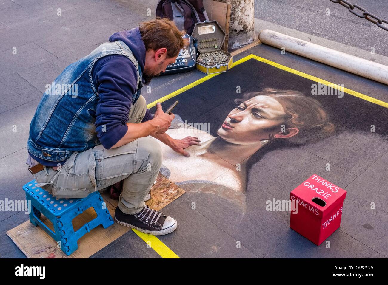 Un artista di strada è dipinto il ritratto di una donna su una passerella Foto Stock