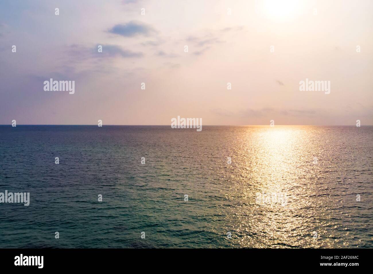 La superficie del mare che riflette il cielo vacanza al sole. La riflessione del sole in acqua di mare Foto Stock