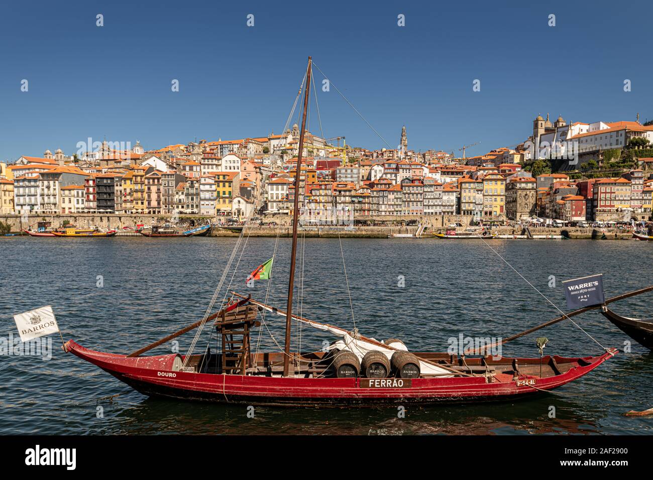 Il vino di Porto barche(Rabelo barche) sul fiume Fiume Douro, con porto attraverso il fiume, Portogallo Foto Stock