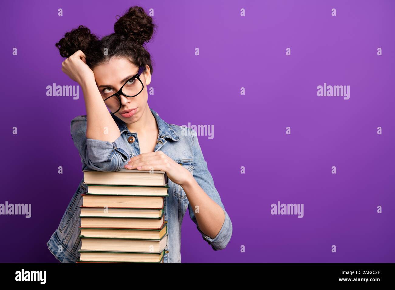 Foto di pretty studente lady poggiando su molti libri stanco della noiosa lezione vogliono andare a casa le specifiche di usura denim casual vestito viola isolato colore di sfondo Foto Stock