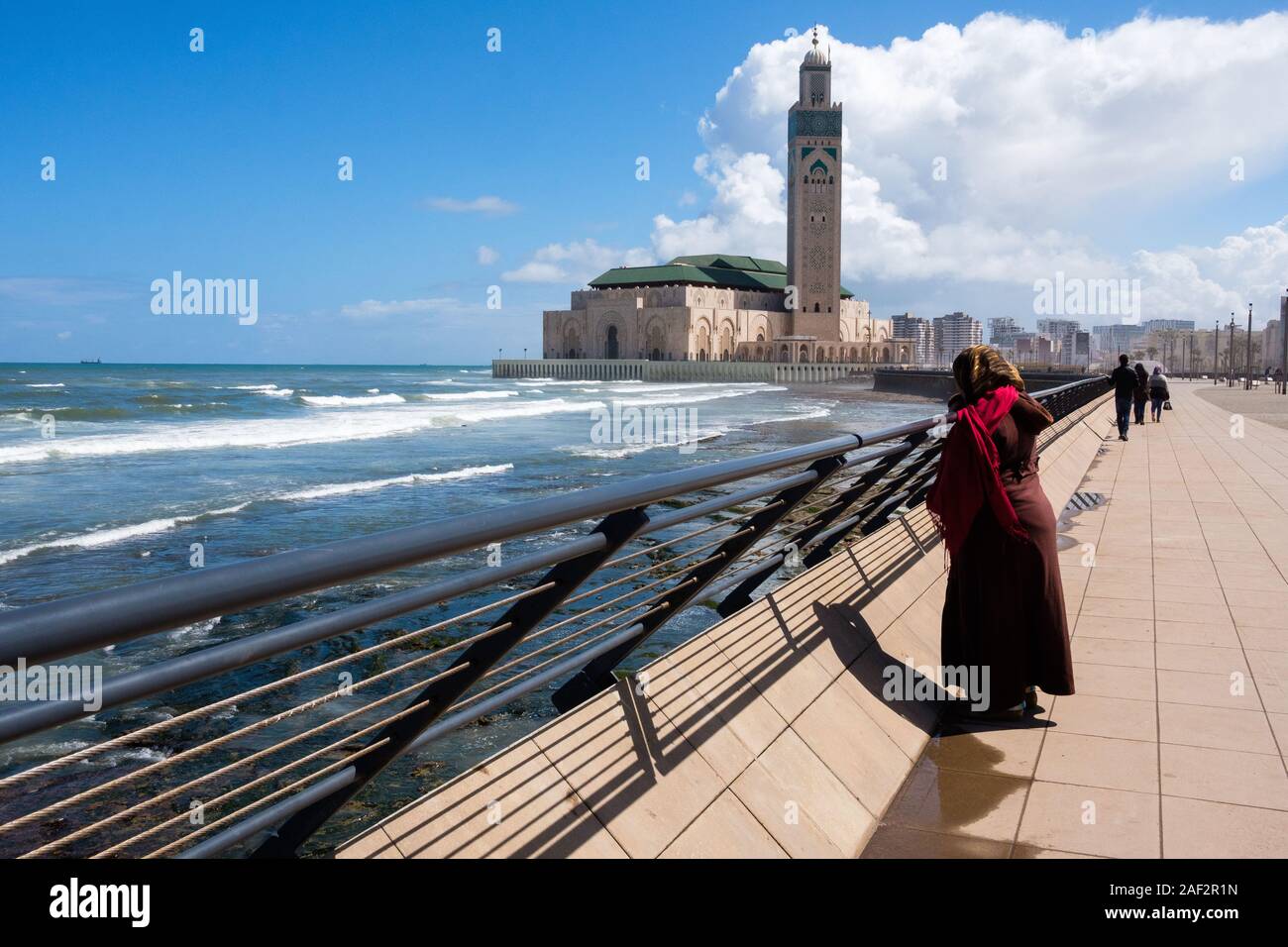Il Marocco, Casablanca: la Moschea di Hassan II progettato dall architetto Michel Pinseau e costruito dal gruppo Bouygues dal mare. Donna sul molo facin Foto Stock