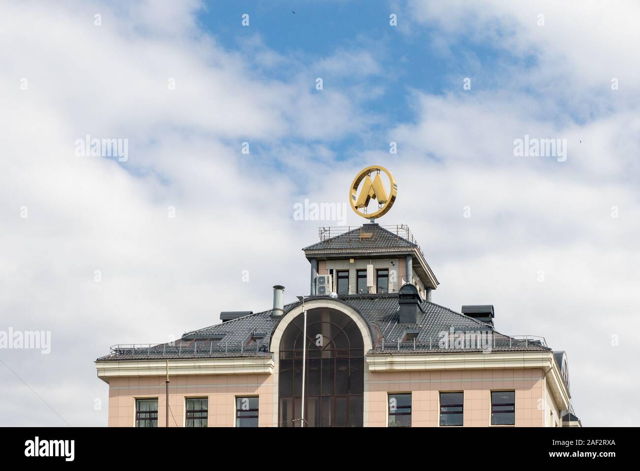 La lettera 'M' è il logo e il simbolo sul tetto dell'edificio contro il cielo Foto Stock