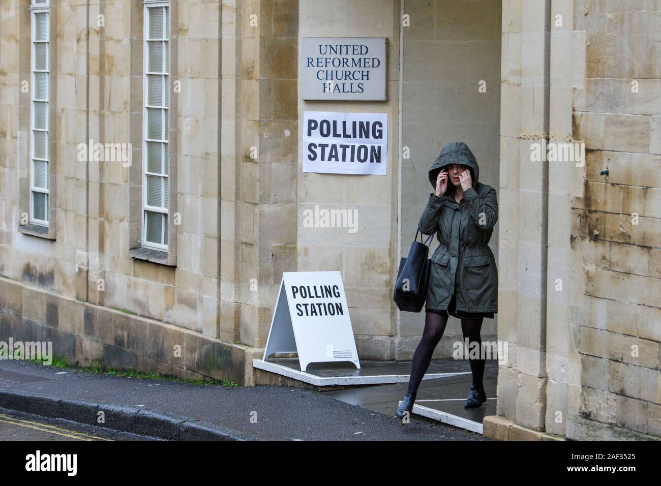 Bagno, Somerset, Regno Unito. 12 Dic, 2019. Una donna sfidando la pioggia battente e di andare a votare nel 2019 elezione generale è raffigurato come lei lascia un seggio che è stato impostato in una sala della chiesa nel centro di Bath. Credito: Lynchpics/Alamy Live News Foto Stock