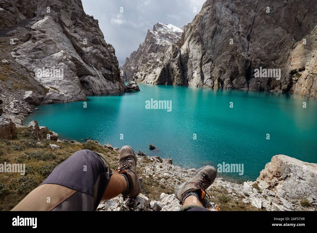Marrone scarpe militari di un escursionista di fronte lago di montagna Kel Suu vicino al confine cinese in Kirghizistan Foto Stock