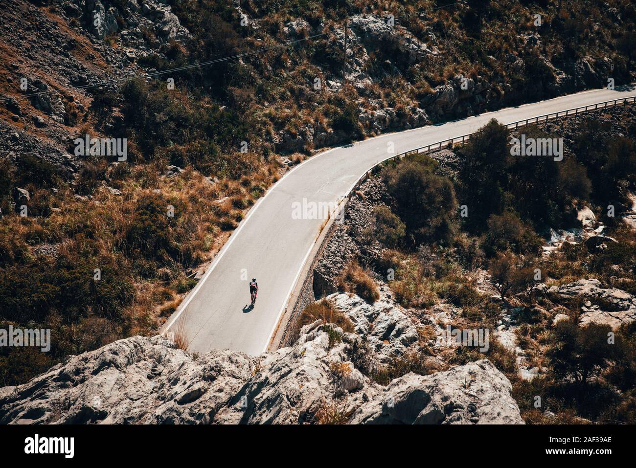 Silhouette del ciclista sulla bicicletta da strada, corsa giù per la collina in montagna Foto Stock