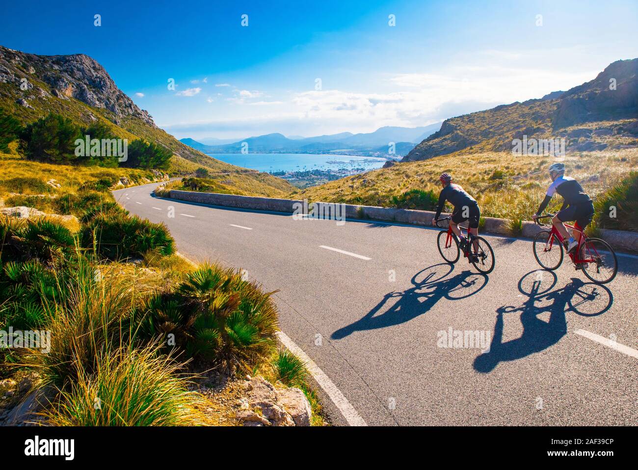 Spazio vuoto. Amici sportiva in bicicletta sul tramonto. Giovane ciclista lungo la costa. Sport nella natura sfondo ciclista su strada in sunset Mallorca, Maiorca, SPAGNA Foto Stock