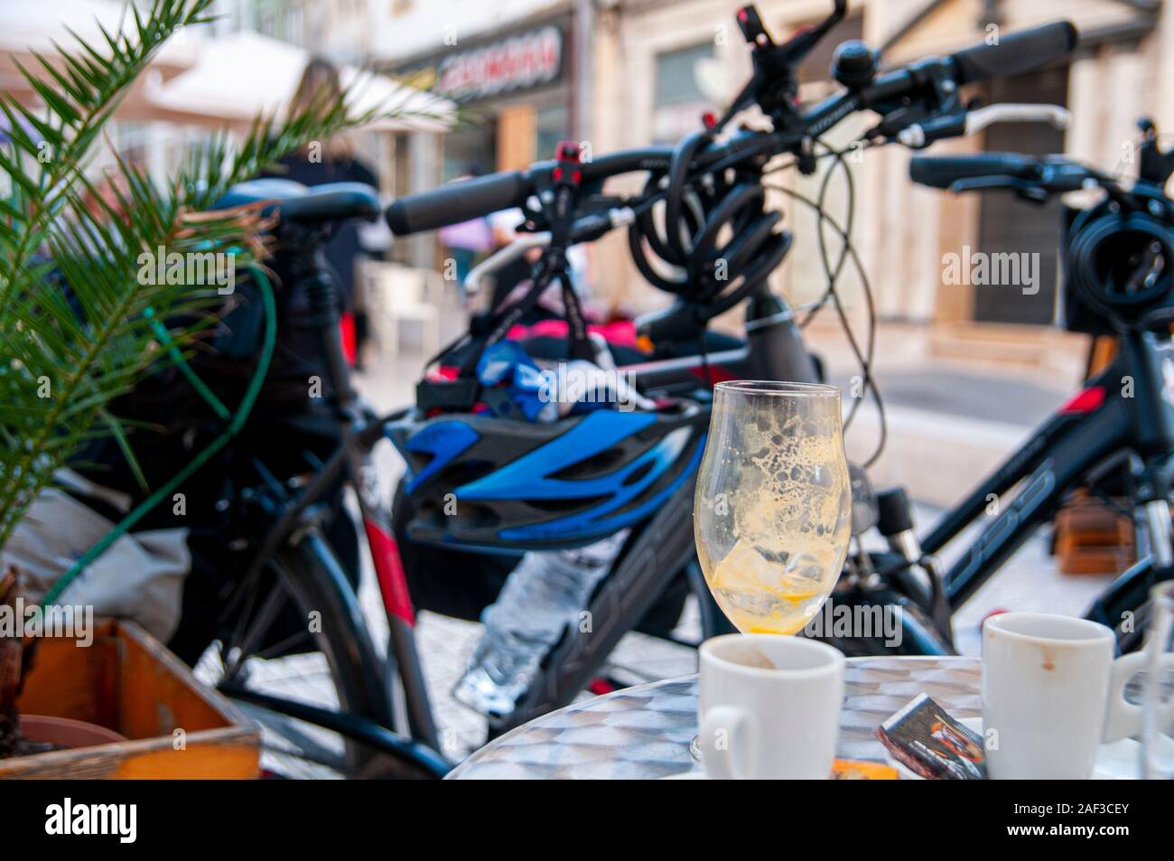 Gita in Bicicletta del concetto. A riposo a un open air cafe le biciclette sono nelle vicinanze. Con un fuori fuoco di fondo urbano. Fotografato a Coimbra, Portogallo Foto Stock