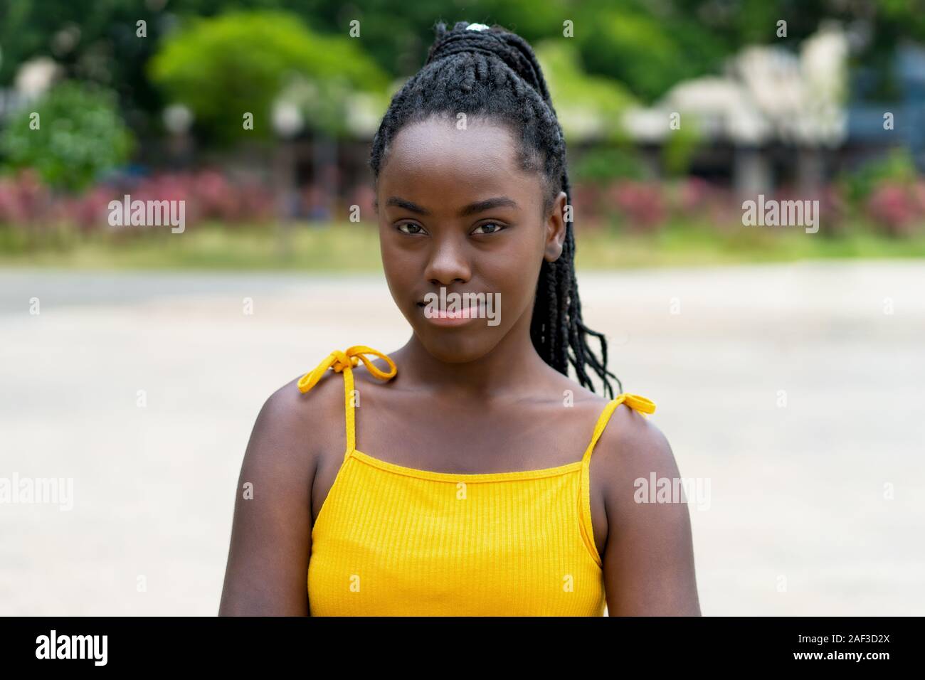 Ritratto di African American donna con dreadlocks all'aperto in estate in città Foto Stock