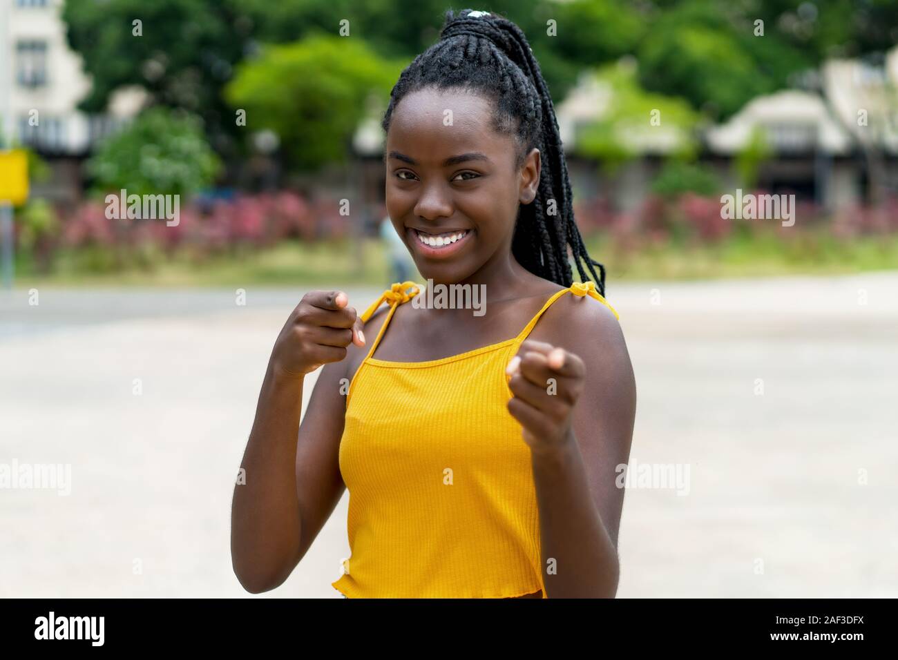 Felice americano africano donna con dreadlocks all'aperto in estate in città Foto Stock
