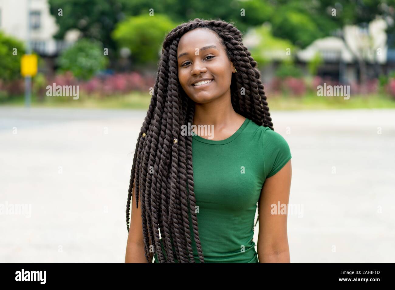 African American giovane donna adulta con fantastica pettinatura all'aperto in estate in città Foto Stock