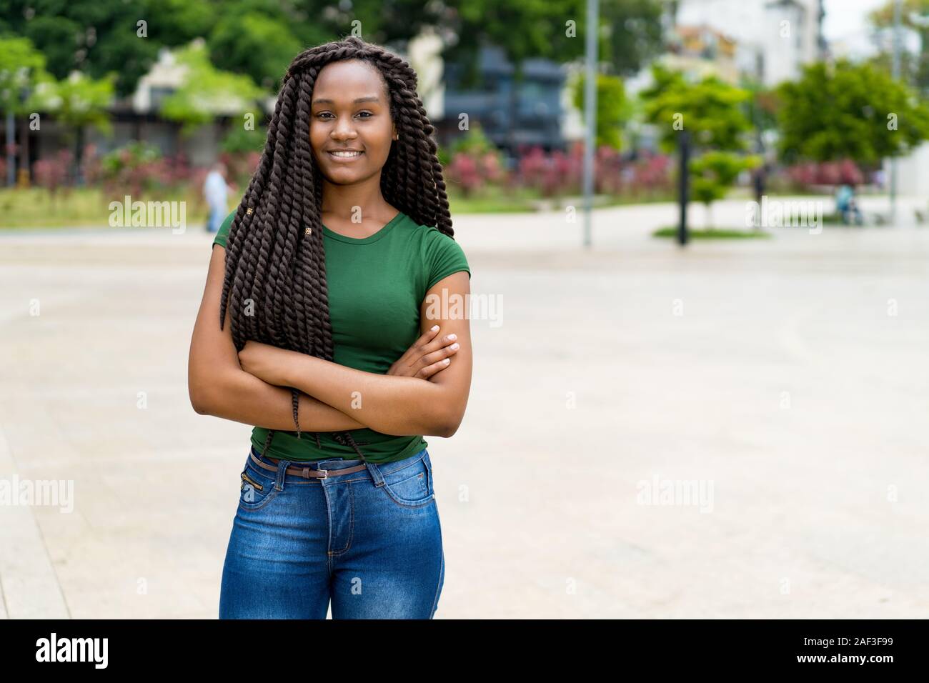 Ridendo americano africano giovane donna adulta con fantastica pettinatura all'aperto in estate in città Foto Stock