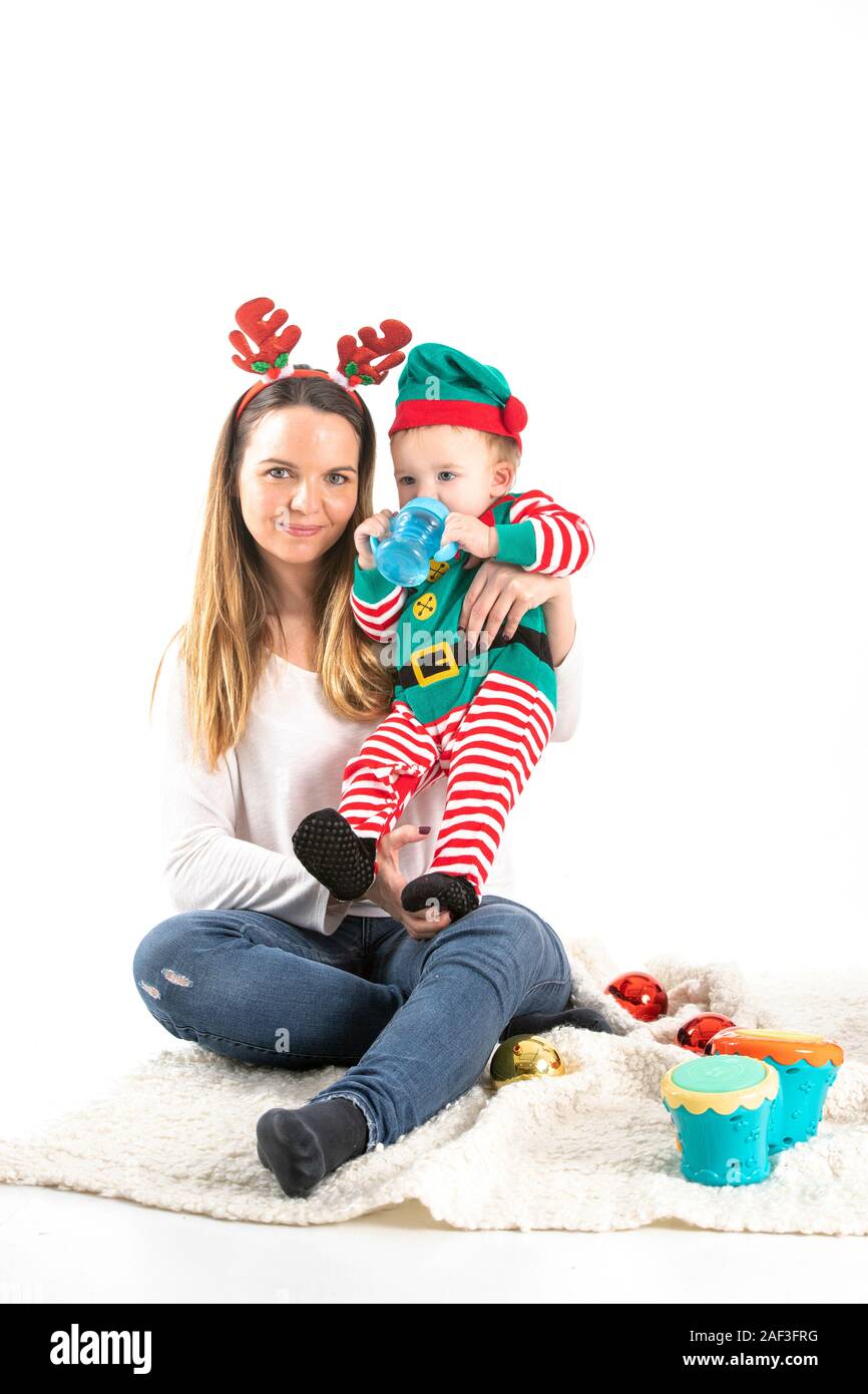 Stock Photo studio con sfondo bianco di una madre e un bambino travestito con elementi di Natale. Foto Stock