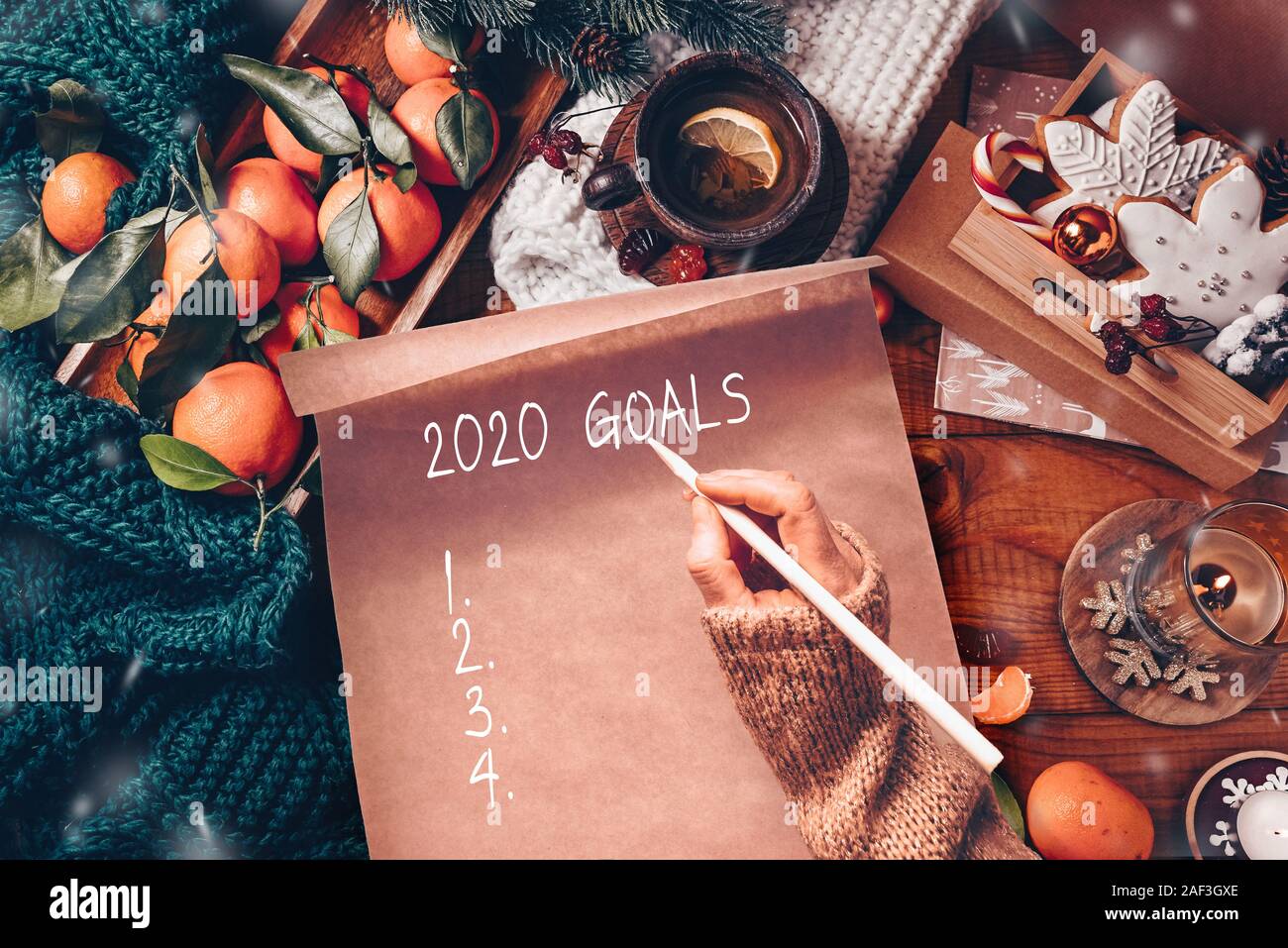 Nuovo Anno decorazioni artigianali e il foglio di carta con il 2020 obiettivi sul tavolo di legno Foto Stock