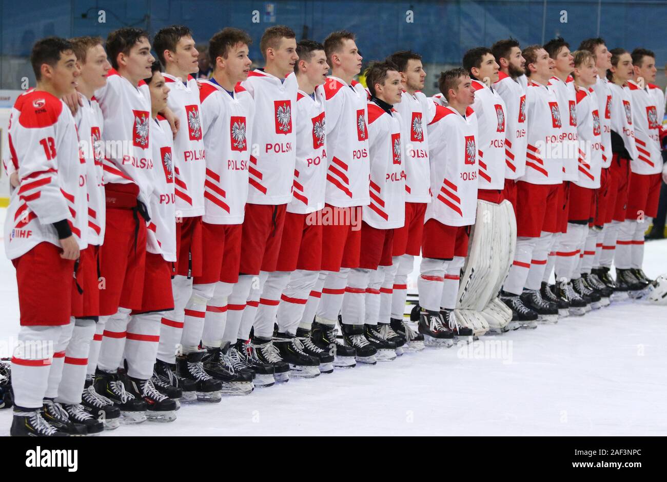 Kiev, Ucraina - 12 dicembre 2019: i giocatori di Polonia la squadra nazionale ascoltare l inno nazionale dopo il 2020 IIHF Hockey su ghiaccio U20 World Championship Div Foto Stock