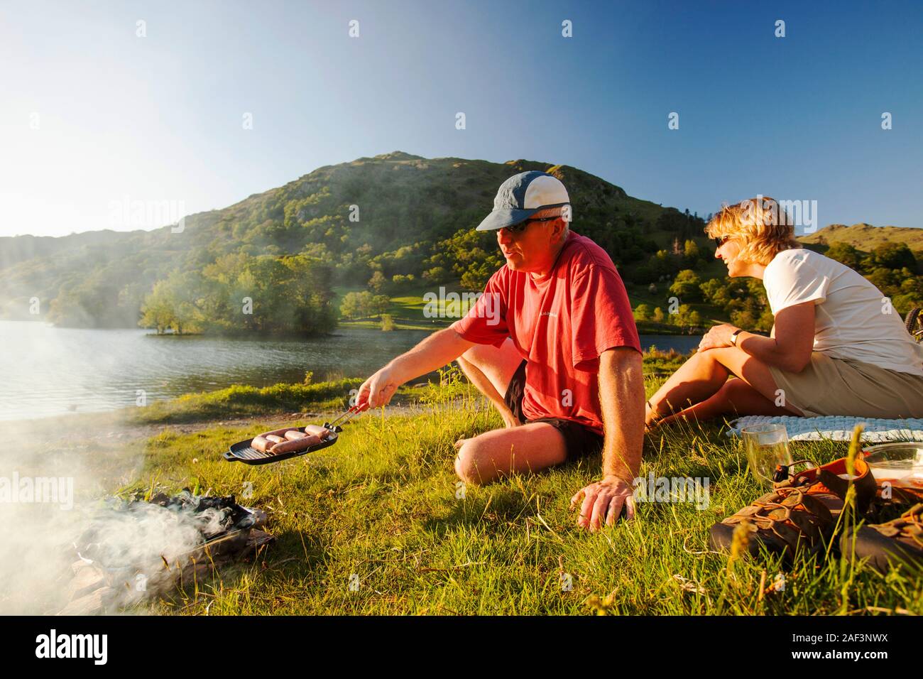 Un paio di godere un barbecue sulle rive del Rydal acqua nel distretto del lago, UK. Foto Stock