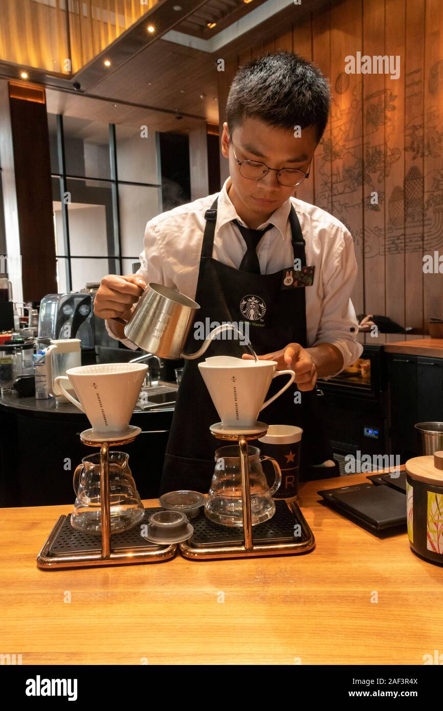 Barista versando il caffè di gocciolamento, riserva di Starbucks Coffee shop, Xian, Cina Foto Stock