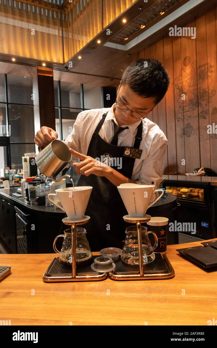 Barista versando il caffè di gocciolamento, riserva di Starbucks Coffee shop, Xian, Cina Foto Stock