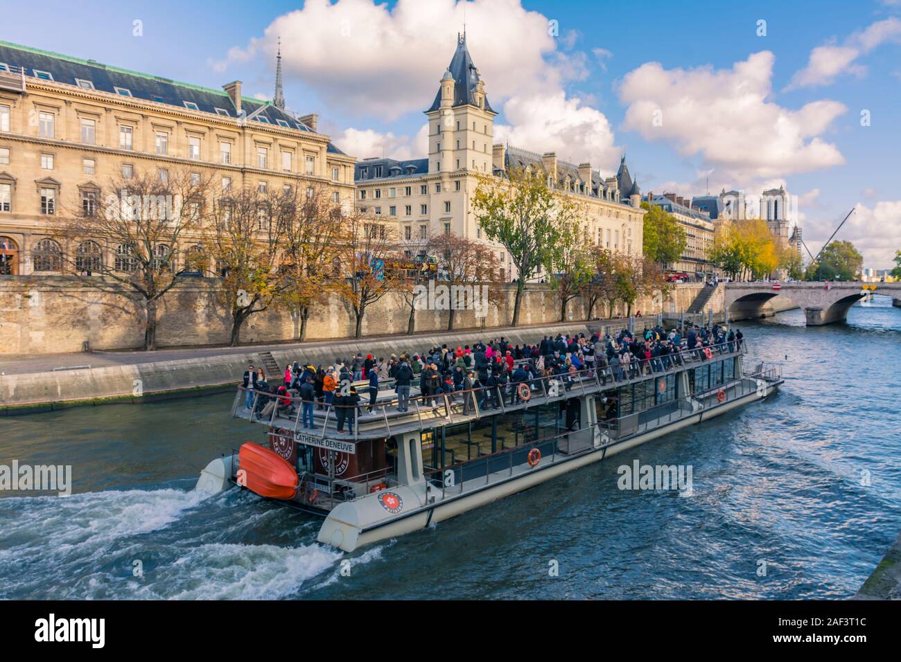 Parigi, Francia - 7 Novembre 2019: un fiume nave che naviga lungo il fiume Senna, accanto al palazzo di giustizia. Ponte Saint-Michele e dietro di esso, Notre Da Foto Stock