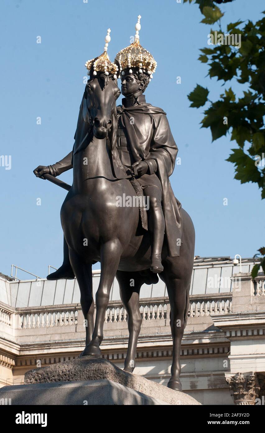 La statua del re George 1V al fianco di Ammiraglio Lord Nelson indossando cappelli in Trafalgar Square come parte di un festival ha commissionato dal sindaco di Londra. Foto Stock