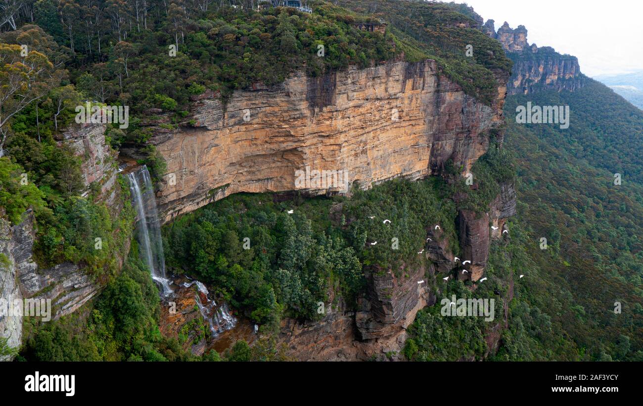 Una cascata nelle Blue Mountains ad ovest di Sydney, Nuovo Galles del Sud, Australia. Guardando verso le tre sorelle rock landmark. Foto Stock