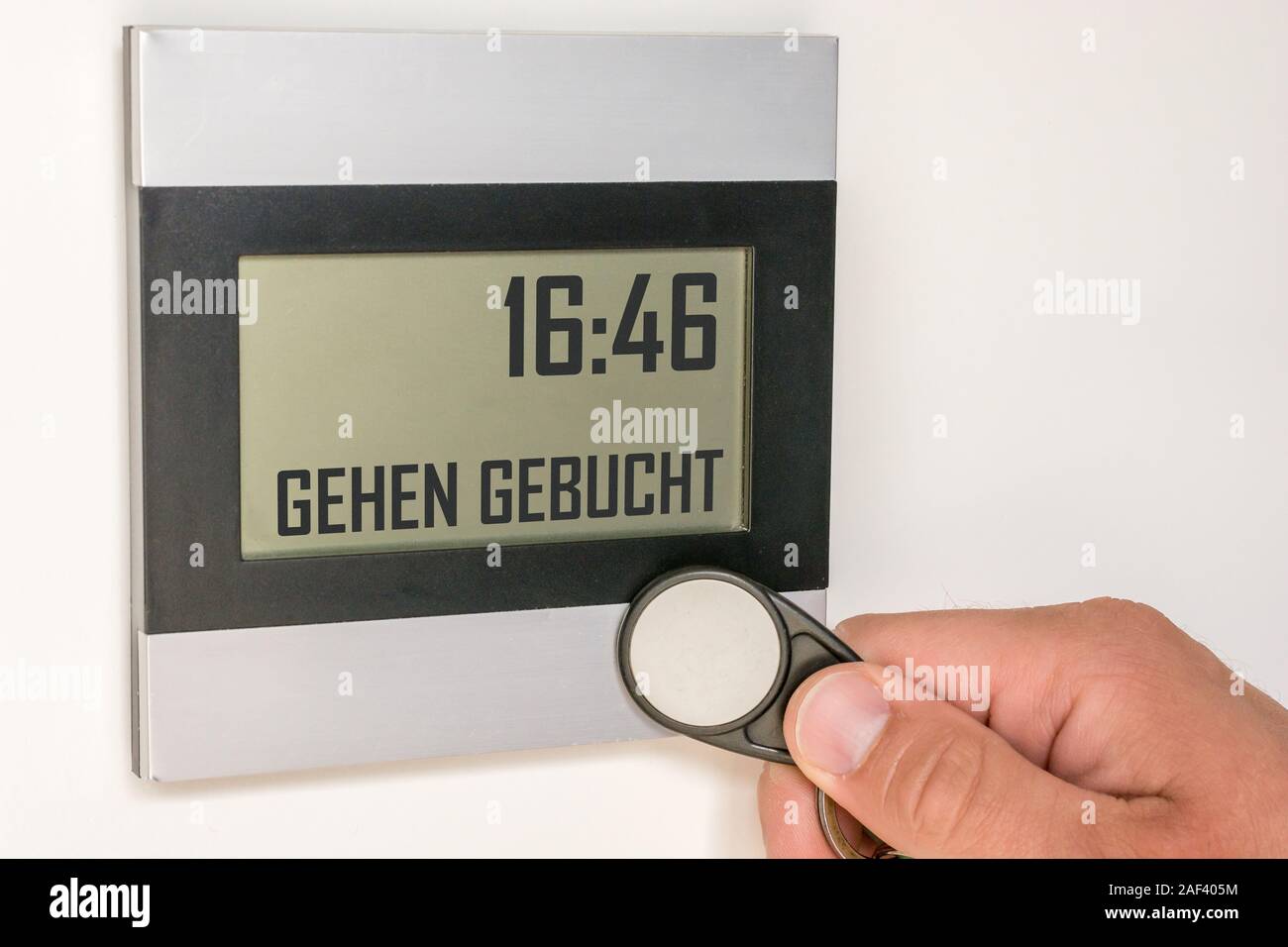 Digital clock di tempo con chip durante il processo di stampaggio di un dipendente con il testo in lingua tedesca "vanno prenotati" Foto Stock