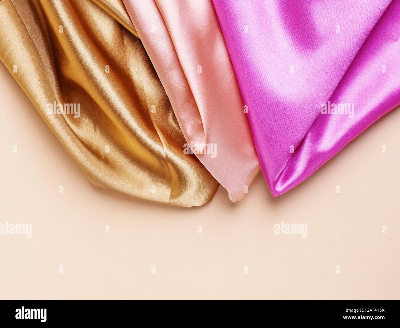 Tessuto colorato stack di seta sfondo. i campioni di tessuto sovrapposti in grande pila di diversi colori rosa e argento, giallo e blu. Vestiti fatti di gara v Foto Stock